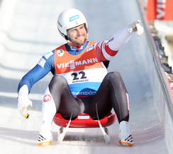 Silver medalist Chris Mazdzer on a luge sled celebrating his victory at the end of his run in the 2018 winter PyeongChang Olympics.