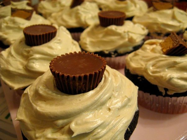 peanut butter frosting and Reeses peanut butter cups topping chocolate cupcakes